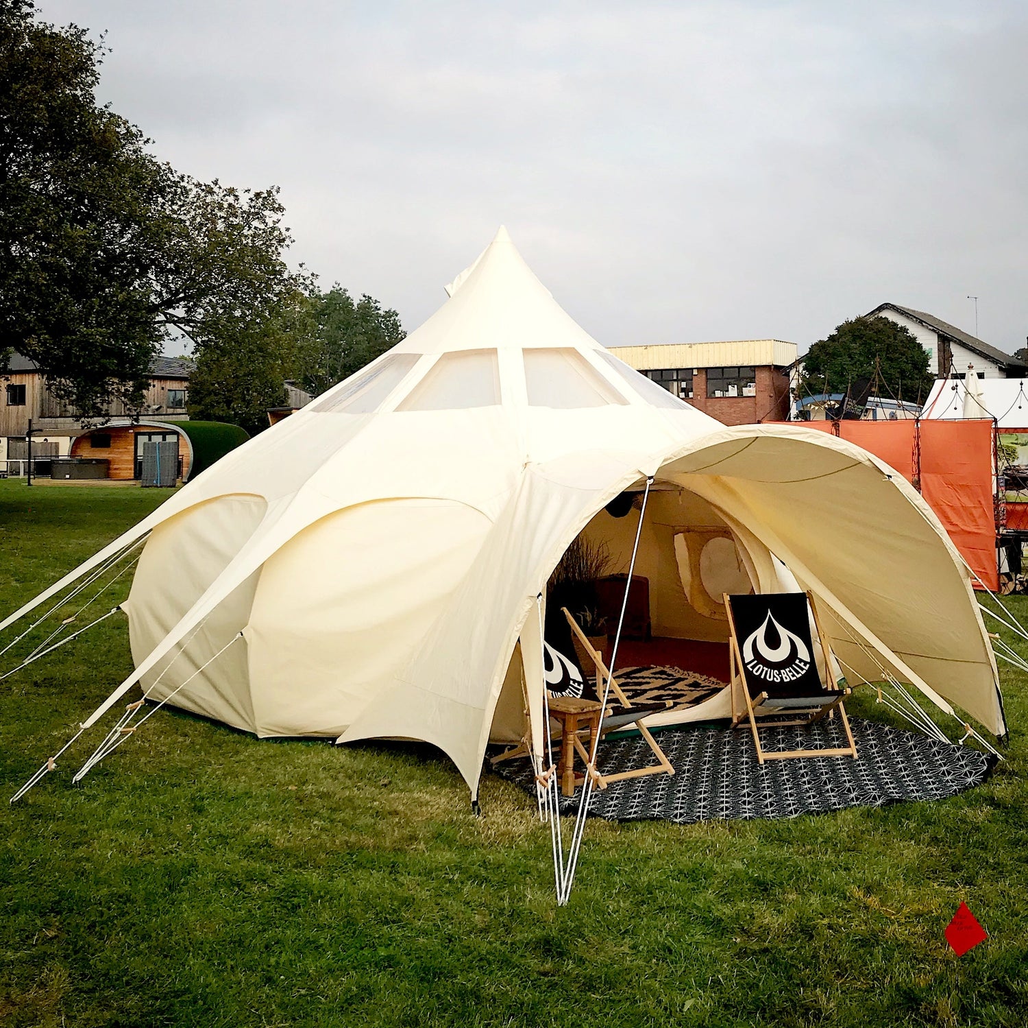 Picture of a Lotus Belle Tent pitched in a field. A luxury, canvas bell tent, but with lots of standing room. Perfect for glamping, events & parties